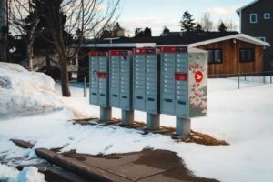 Community mailboxes in a snow-covered suburban neighborhood during winter season.