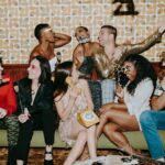 Group of friends enjoying a lively New Year's Eve party with laughter and festive decorations.