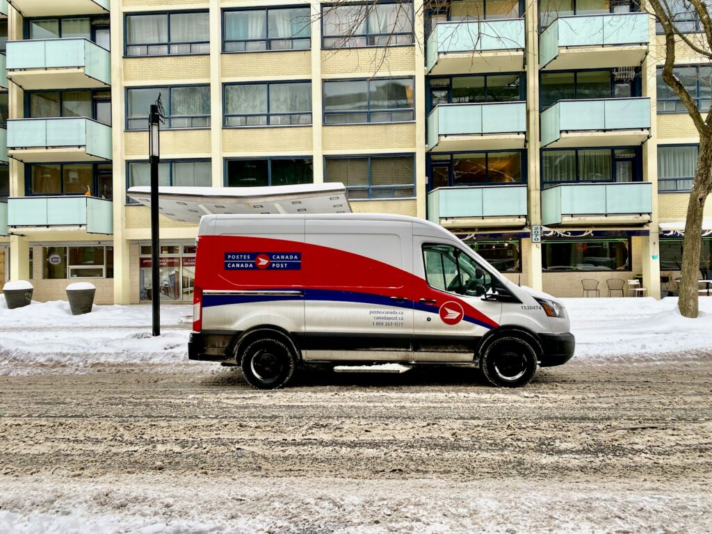 blue and white van parked near white concrete building during daytime