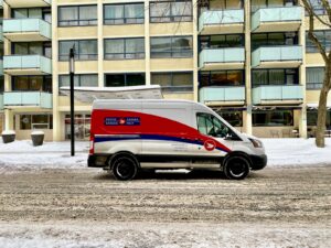 blue and white van parked near white concrete building during daytime