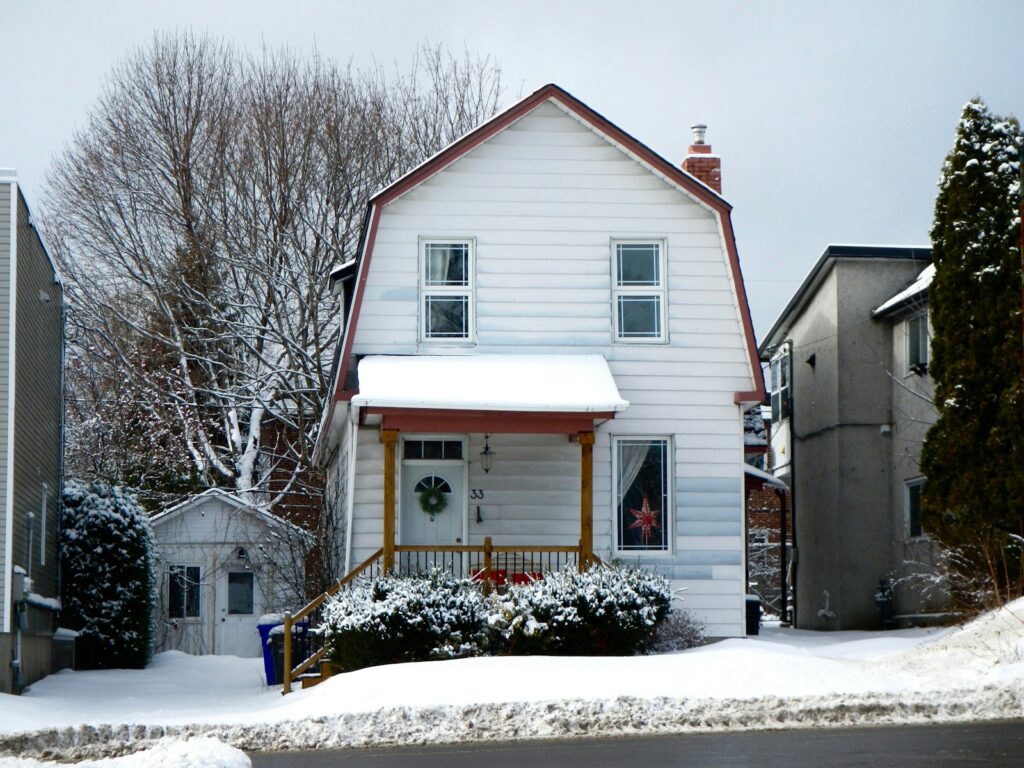 white and brown wooden house near bare trees during daytime