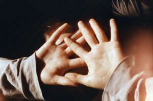 A person covering their face with their hands