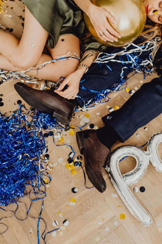 Exciting party scene with confetti and balloons strewn across a wooden floor.