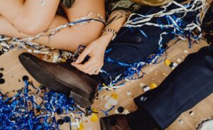 Exciting party scene with confetti and balloons strewn across a wooden floor.