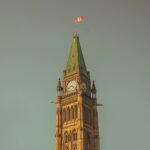 a tall clock tower with a flag on top