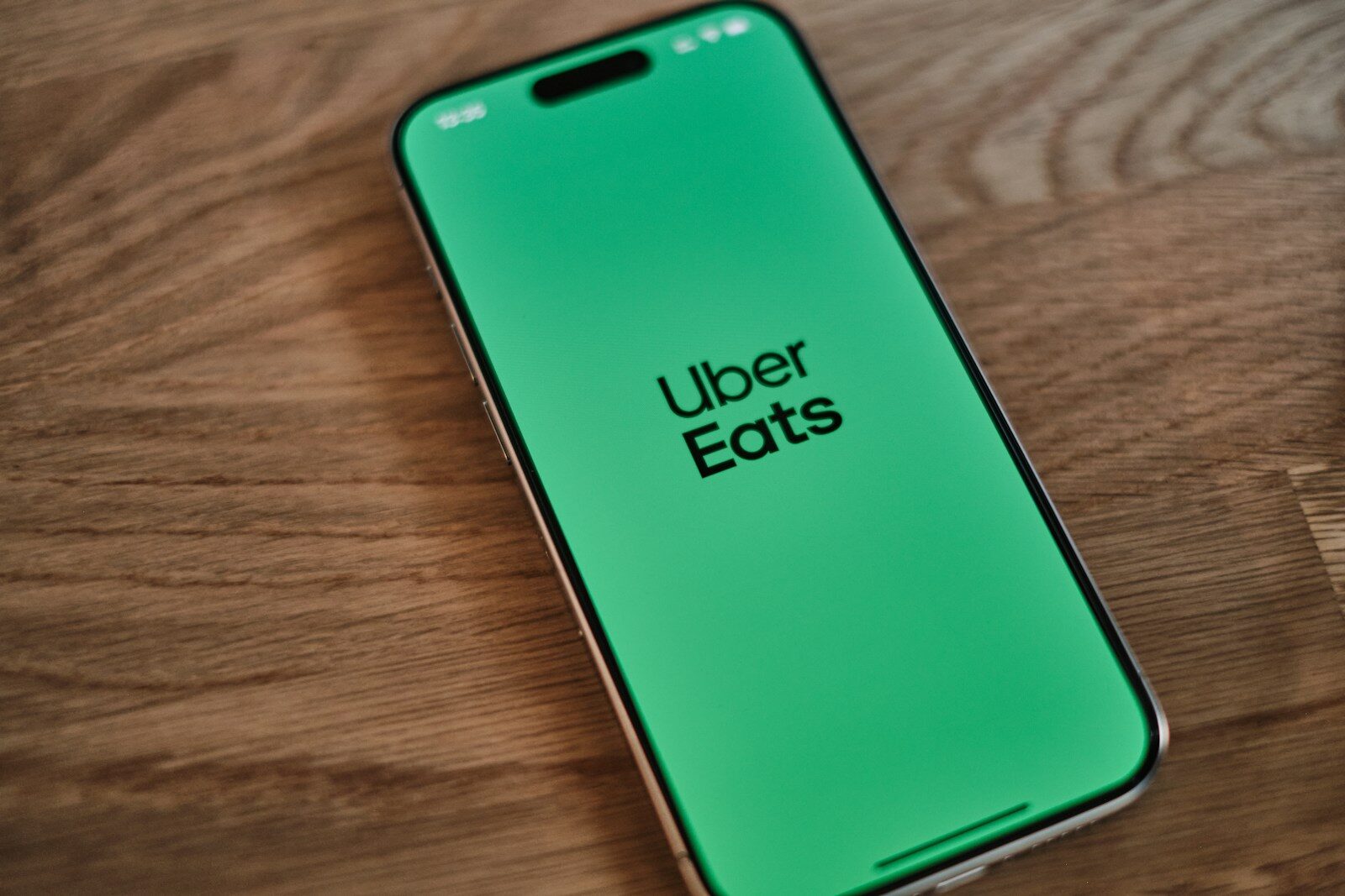 A green iPhone sitting on top of a wooden table