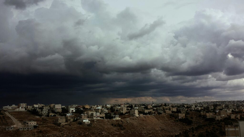Ominous storm clouds over a city landscape illustrating the gathering storm of the Iran war.