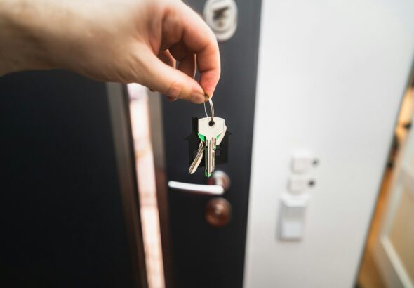 A person is holding a key to a door