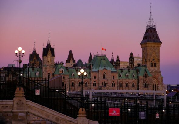 a large building with a clock tower next to a fence