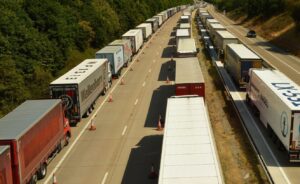 Trade War Fatigue: Long lines of transport trucks at a Canada-U.S. border crossing symbolize ongoing tariff disputes between Canada and the United States.