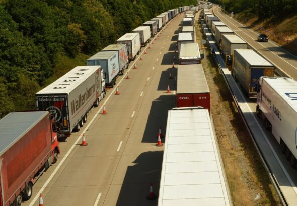 Trade War Fatigue: Long lines of transport trucks at a Canada-U.S. border crossing symbolize ongoing tariff disputes between Canada and the United States.