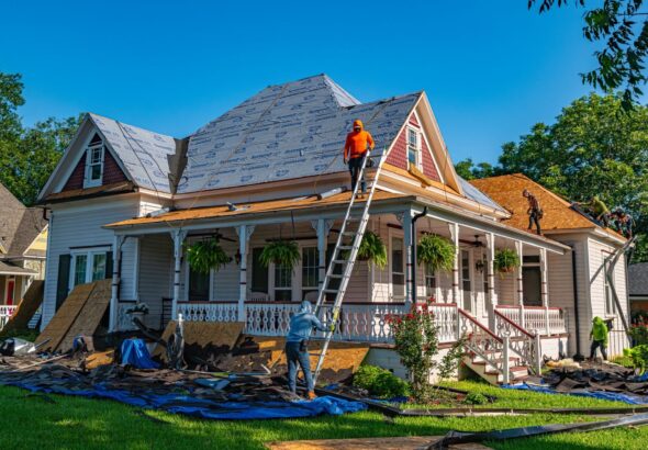 Roofers replace the roof of a historic home in Weatherford, Texas.