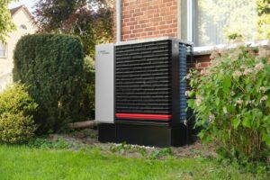 Outdoor heat pump unit next to a brick building