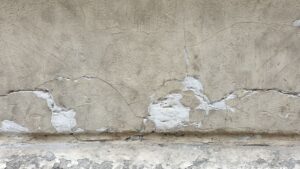 A detailed view of a cracked concrete wall showcasing weathered textures and patterns.