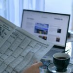 Morning newspaper and laptop representing the day's news briefing