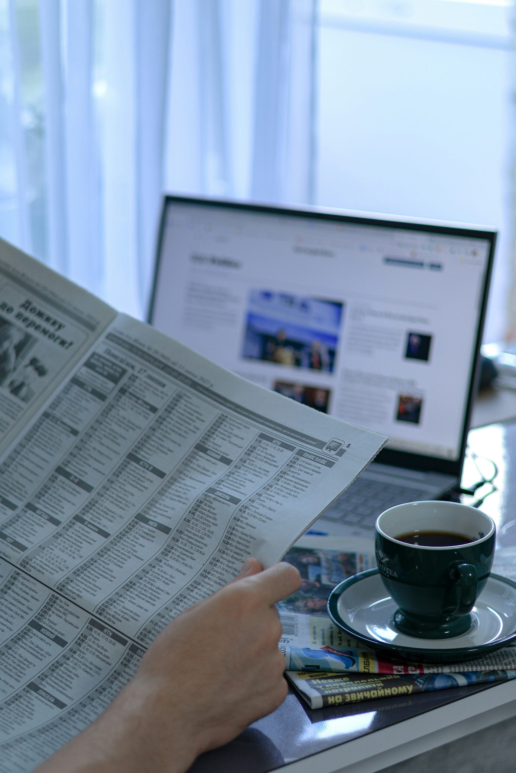 Morning newspaper and laptop representing the day's news briefing