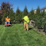 A man mowing a lawn with a lawn mower