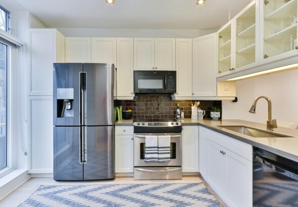 silver french door refrigerator beside white wooden kitchen cabinet