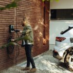 a woman is using a power washer on a brick wall